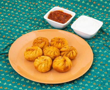 Kızarmış Momos, Nepal 'den geleneksel bir hamur yemeğidir. Schezwan Sosu ve Krema ile servis edilir.