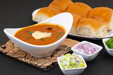 Pav Bhaji bir Hint Geleneksel Popüler Sokak Fast Food 'udur. Kalın ve baharatlı baharatlı köri yanında yumuşak ekmek rulosu ve tereyağlı çörek.