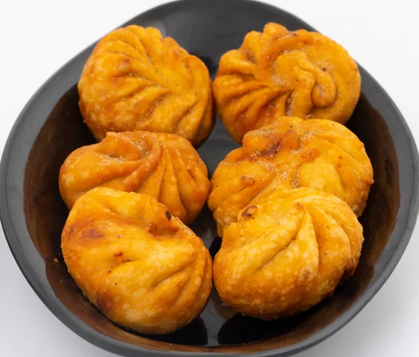 Kızarmış Momos, Nepal 'den geleneksel bir hamur yemeğidir. Schezwan Sosu ve Krema ile servis edilir.