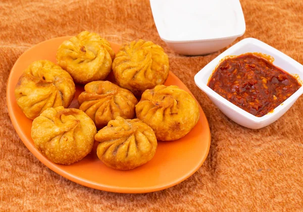 Kızarmış Momos, Nepal 'den geleneksel bir hamur yemeğidir. Schezwan Sosu ve Krema ile servis edilir.