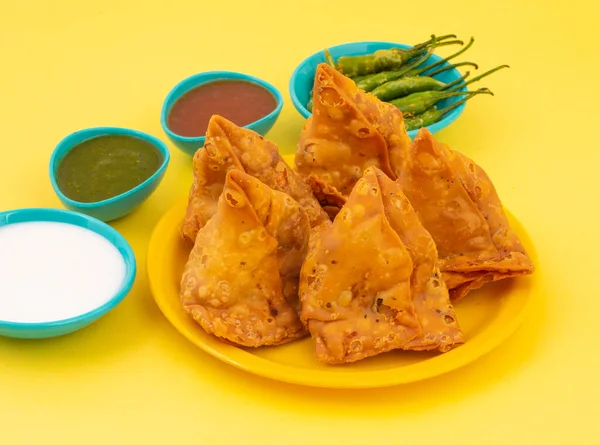 Hint Sokak Yemeği Samosa ya da Samosas, Maida & Doldurulmuş Patates, Bezelye ve Baharatların Çıtır Çıtır Çıtır Çıtır ve Baharatlı Üçgen Şekerlemesidir. Chutney, Ketçap veya Curd ile servis edilir.