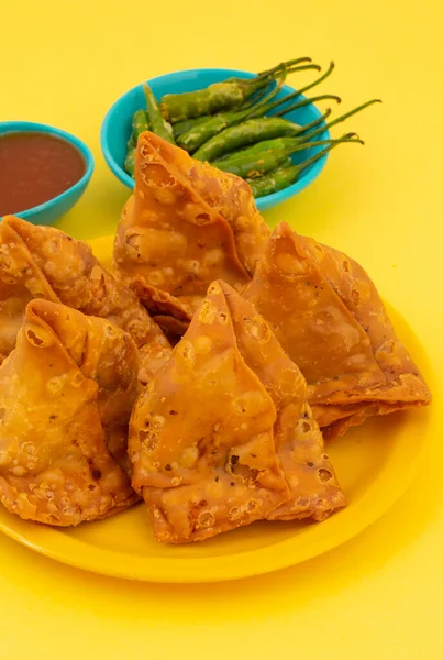 Hint Sokak Yemeği Samosa ya da Samosas, Maida & Doldurulmuş Patates, Bezelye ve Baharatların Çıtır Çıtır Çıtır Çıtır ve Baharatlı Üçgen Şekerlemesidir. Chutney, Ketçap veya Curd ile servis edilir.