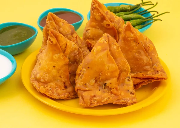 Hint Sokak Yemeği Samosa ya da Samosas, Maida & Doldurulmuş Patates, Bezelye ve Baharatların Çıtır Çıtır Çıtır Çıtır ve Baharatlı Üçgen Şekerlemesidir. Chutney, Ketçap veya Curd ile servis edilir.