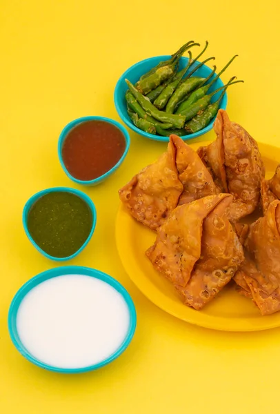 Hint Sokak Yemeği Samosa ya da Samosas, Maida & Doldurulmuş Patates, Bezelye ve Baharatların Çıtır Çıtır Çıtır Çıtır ve Baharatlı Üçgen Şekerlemesidir. Chutney, Ketçap veya Curd ile servis edilir.