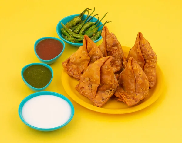 Hint Sokak Yemeği Samosa ya da Samosas, Maida & Doldurulmuş Patates, Bezelye ve Baharatların Çıtır Çıtır Çıtır Çıtır ve Baharatlı Üçgen Şekerlemesidir. Chutney, Ketçap veya Curd ile servis edilir.