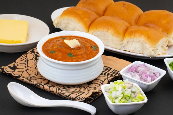 Pav Bhaji bir Hint Geleneksel Popüler Sokak Fast Food 'udur. Kalın ve baharatlı baharatlı köri yanında yumuşak ekmek rulosu ve tereyağlı çörek.