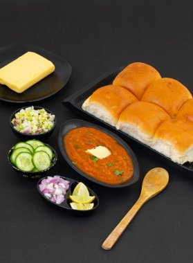 Pav Bhaji bir Hint Geleneksel Popüler Sokak Fast Food 'udur. Kalın ve baharatlı baharatlı köri yanında yumuşak ekmek rulosu ve tereyağlı çörek.