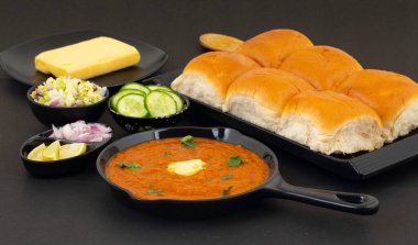 Pav Bhaji bir Hint Geleneksel Popüler Sokak Fast Food 'udur. Kalın ve baharatlı baharatlı köri yanında yumuşak ekmek rulosu ve tereyağlı çörek.
