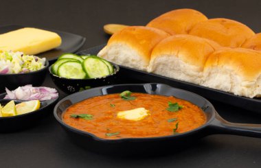 Pav Bhaji bir Hint Geleneksel Popüler Sokak Fast Food 'udur. Kalın ve baharatlı baharatlı köri yanında yumuşak ekmek rulosu ve tereyağlı çörek.