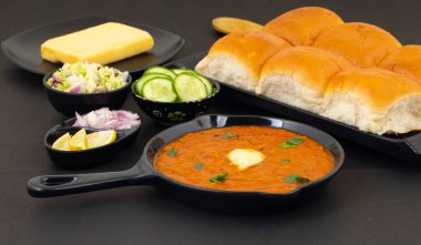 Pav Bhaji bir Hint Geleneksel Popüler Sokak Fast Food 'udur. Kalın ve baharatlı baharatlı köri yanında yumuşak ekmek rulosu ve tereyağlı çörek.