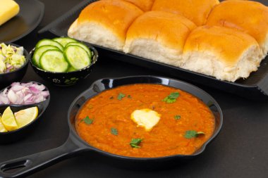 Pav Bhaji bir Hint Geleneksel Popüler Sokak Fast Food 'udur. Kalın ve baharatlı baharatlı köri yanında yumuşak ekmek rulosu ve tereyağlı çörek.