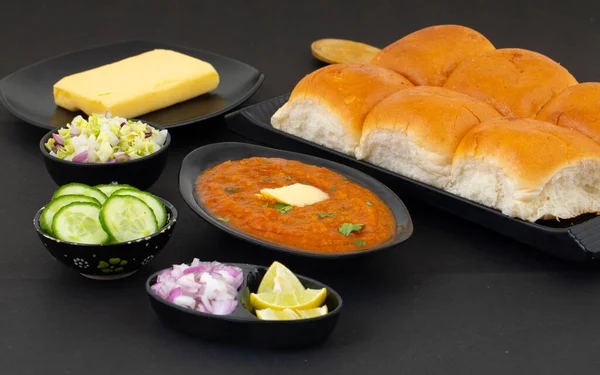Pav Bhaji bir Hint Geleneksel Popüler Sokak Fast Food 'udur. Kalın ve baharatlı baharatlı köri yanında yumuşak ekmek rulosu ve tereyağlı çörek.