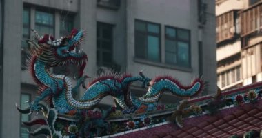 Longshan Tapınağı'nda çatı dekoratif heykel ile arka plan üzerinde modern bir bina. Taipei, Tayvan