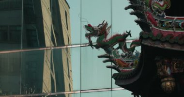 Longshan Tapınağı'nda çatı dekoratif heykel ile arka plan üzerinde modern bir bina. Taipei, Tayvan