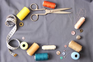 birçok dikiş ipliği farklı renk, kumaş, terzi makas, düğmeler, iğneler. Dikiş aksesuarları bir çerçevede koyulur.