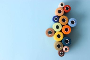 renkli bir arka plan üzerinde farklı renklerde dikiş ipliği. Üstten Görünüm 