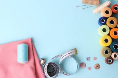 Dikiş aksesuarları ve kumaş üzerine beyaz bir arka plan. Dikiş ipliği, iğneleri, iğne, kumaş, düğmeler ve dikiş santimetre. Üstten Görünüm, flatlay