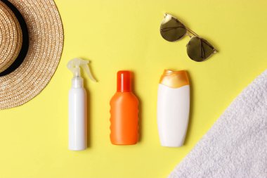 Güneş kremi, havlu, şapka, gözlük renkli bir arka plan üzerinde. Kozmetik sunburn.top görünümü, flatlay önlenmesi için 
