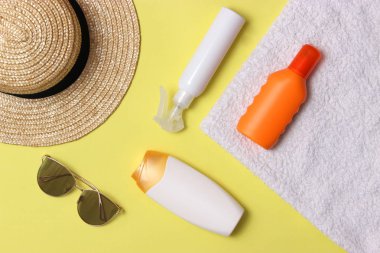 Güneş kremi, havlu, şapka, gözlük renkli bir arka plan üzerinde. Kozmetik sunburn.top görünümü, flatlay önlenmesi için 