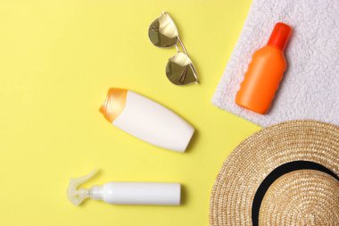 Güneş kremi, havlu, şapka, gözlük renkli bir arka plan üzerinde. Kozmetik sunburn.top görünümü, flatlay önlenmesi için 