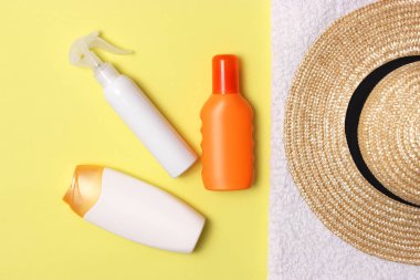 Güneş kremi, havlu, şapka, gözlük renkli bir arka plan üzerinde. Kozmetik sunburn.top görünümü, flatlay önlenmesi için 