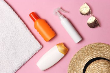Güneş kremi, havlu, şapka, gözlük renkli bir arka plan üzerinde. Kozmetik sunburn.top görünümü, flatlay önlenmesi için 