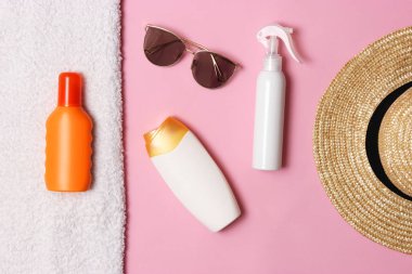 Güneş kremi, havlu, şapka, gözlük renkli bir arka plan üzerinde. Kozmetik sunburn.top görünümü, flatlay önlenmesi için 