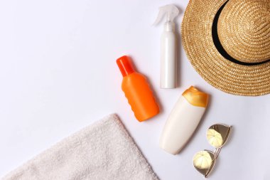 Güneş kremi, havlu, şapka, gözlük beyaz zemin üzerinde. Kozmetik için güvenli sunburn.top görünümü, flatlay 