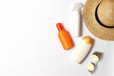 Güneş kremi, havlu, şapka, gözlük beyaz zemin üzerinde. Kozmetik için güvenli sunburn.top görünümü, flatlay 