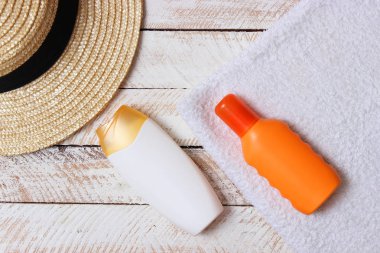 Güneş kremi, havlu, şapka, gözlük ahşap arka plan üzerinde. minimalizm, üstten görünüm, flatlay 
