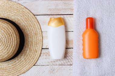 Güneş kremi, havlu, şapka, gözlük ahşap arka plan üzerinde. minimalizm, üstten görünüm, flatlay 