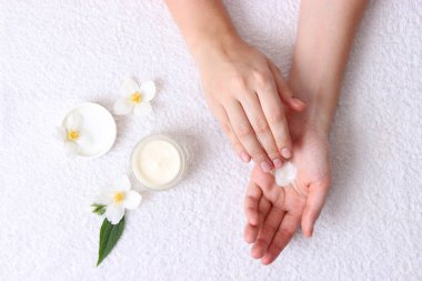 Kız onu eller kozmetik krem bir havlu arka plan üzerinde smear. Cilt Bakımı, elastik ve genç cilt hands.top görünümü. 