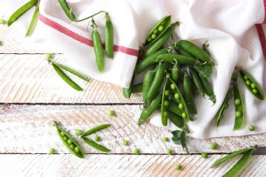 Yeşil bezelye ve bezelye hafif bir arka plan üzerinde güzel bir kompozisyon.