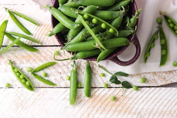 Yeşil bezelye ve bezelye hafif bir arka plan üzerinde güzel bir kompozisyon.