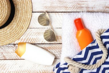 plaj çantası plaj aksesuarları bir ahşap arka plan en iyi görünümü ile. Plaj çantası, havlu, güneş kremi, gözlük, şapka.