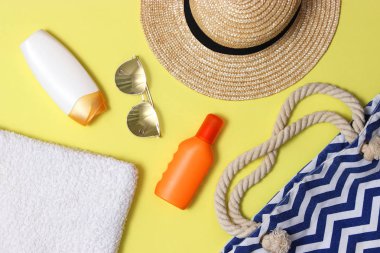 plaj çantası plaj aksesuarları bir renkli arka plan en iyi görünümü ile. Güneş kremi, havlu, gözlük, şapka.