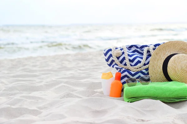 Čepice Plážové Tašky Opalovací Krém Brýle Ručník Pláži Pozadí Moře — Stock fotografie