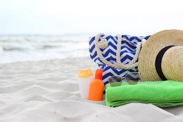 Čepice Plážové Tašky Opalovací Krém Brýle Ručník Pláži Pozadí Moře — Stock fotografie