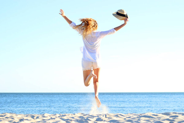 the girl is jumping against the sea.