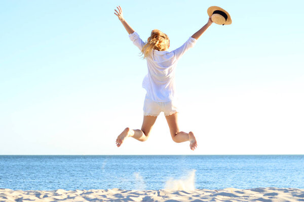 the girl is jumping against the sea.