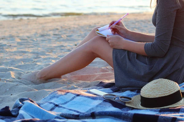 girl with a paper notebook by the sea works. freelancing