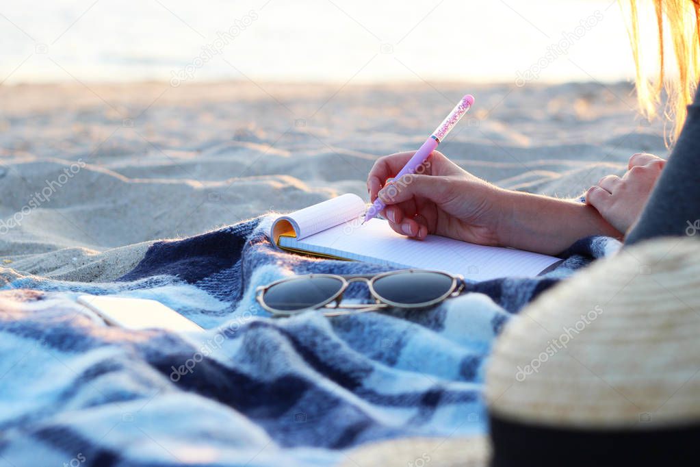 girl with a paper notebook by the sea works. freelancing