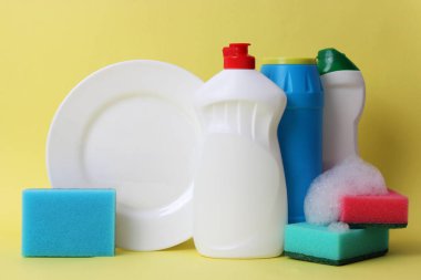 bulaşık sıvısı, süngerler, renkli arka planda plaka. ev işleri, Yıkama yemekleri