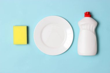 Bulaşık yıkama yardımcıları, Süngerler ve renkli bir arka planda bir plaka, üst görünüm. Ev işi, yemekleri yıka. flatlay