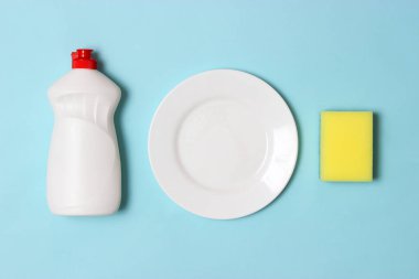 Bulaşık yıkama yardımcıları, Süngerler ve renkli bir arka planda bir plaka, üst görünüm. Ev işi, yemekleri yıka. flatlay