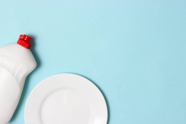 Bulaşık yıkama yardımcıları, Süngerler ve renkli bir arka planda bir plaka, üst görünüm. Ev işi, yemekleri yıka. flatlay