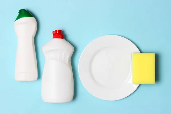dish washing aids, sponges and a plate on a colored background, top view. Housework, wash the dishes.flatlay