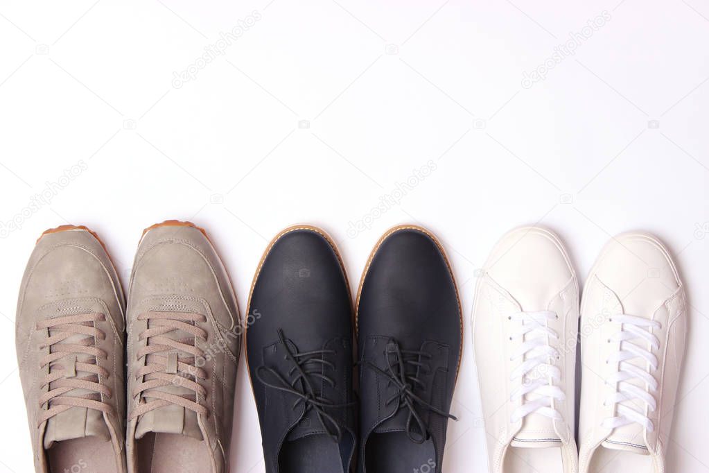 men's office shoes and sneakers on a white background top view. a set of men's shoes, a choice.