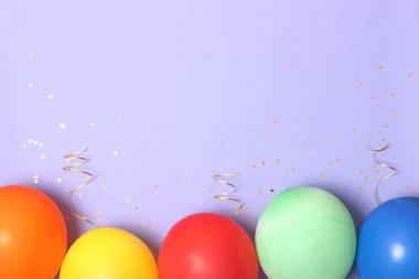 Balonlar, kurdeleler ve konfeti bir renkli arka plan üstüne görüntüleyin. Kutlama
