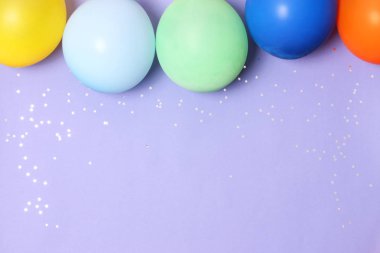 Balonlar, kurdeleler ve konfeti bir renkli arka plan üstüne görüntüleyin. Kutlama